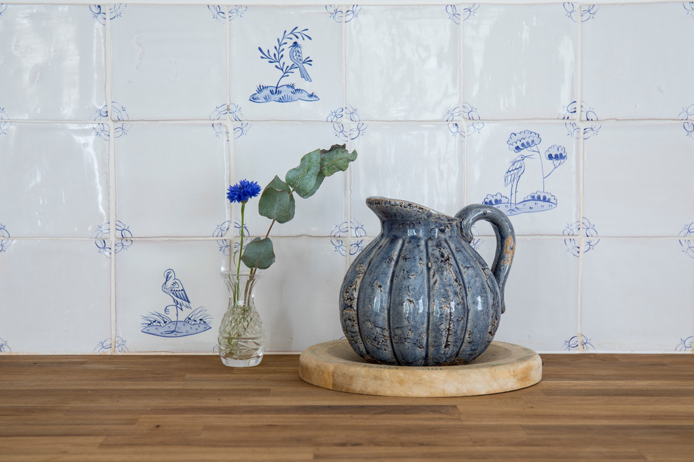 Inspiration för stora lantliga kök, med en rustik diskho, skåp i shakerstil, blå skåp, träbänkskiva, vitt stänkskydd, stänkskydd i keramik, integrerade vitvaror, kalkstensgolv och blått golv
