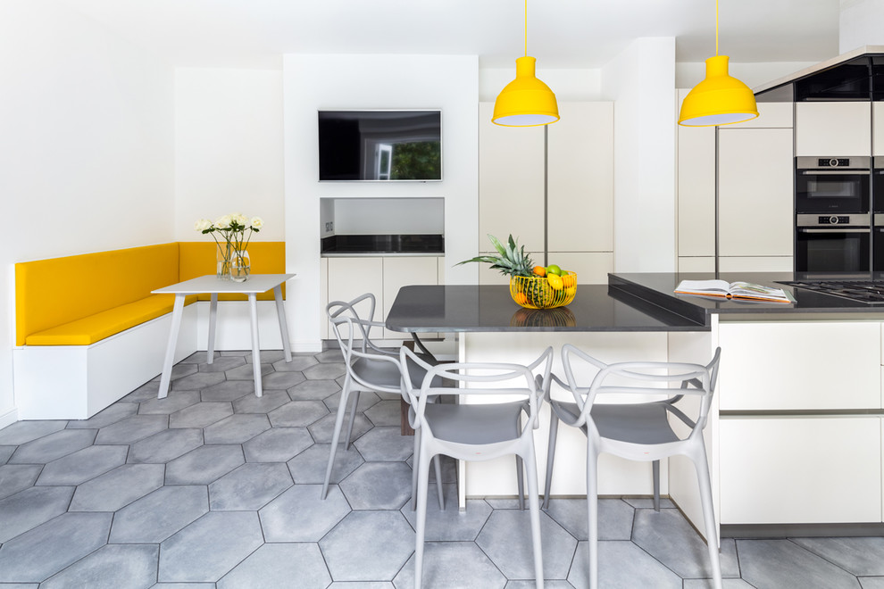 Einzeilige, Mittelgroße Moderne Küche mit flächenbündigen Schrankfronten, Küchengeräten aus Edelstahl, Kücheninsel, grauem Boden und grauer Arbeitsplatte in London