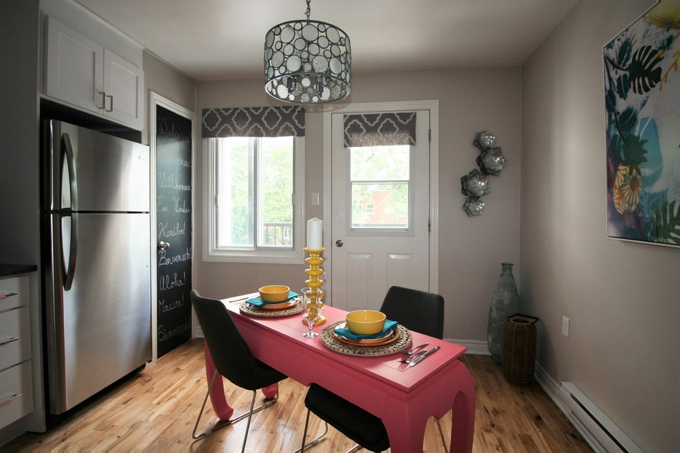 Inredning av ett modernt avskilt, mellanstort grå grått l-kök, med en undermonterad diskho, skåp i shakerstil, vita skåp, granitbänkskiva, vitt stänkskydd, stänkskydd i porslinskakel, rostfria vitvaror, ljust trägolv och gult golv