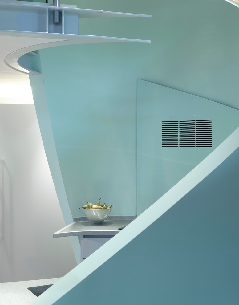 Aménagement d'une grande cuisine ouverte contemporaine avec un évier encastré, un placard à porte plane, des portes de placard bleues, un plan de travail en surface solide, un électroménager blanc et une péninsule.