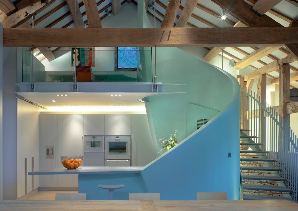 Idee per una grande cucina ad ambiente unico design con lavello sottopiano, ante lisce, ante blu, top in superficie solida, elettrodomestici bianchi e penisola