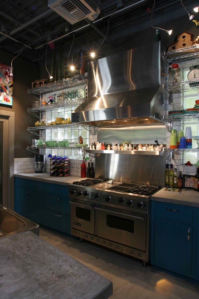 Inredning av ett eklektiskt mellanstort kök, med en rustik diskho, släta luckor, blå skåp, bänkskiva i betong, rostfria vitvaror, betonggolv, vitt stänkskydd, stänkskydd i keramik och en köksö