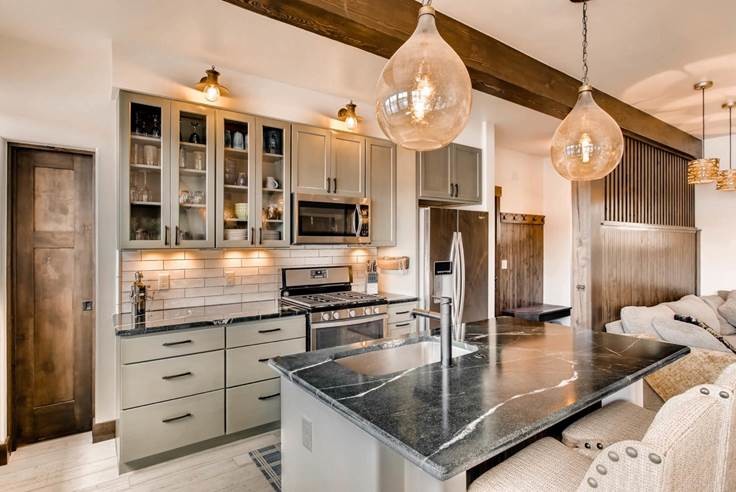 Example of a small mountain style single-wall light wood floor open concept kitchen design in Denver with an undermount sink, shaker cabinets, beige cabinets, granite countertops, white backsplash, subway tile backsplash and an island