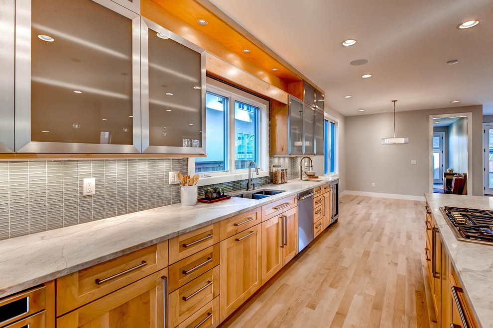 Example of a huge trendy l-shaped light wood floor open concept kitchen design in Denver with glass-front cabinets, light wood cabinets, quartz countertops, gray backsplash, ceramic backsplash, stainless steel appliances, an island and an undermount sink