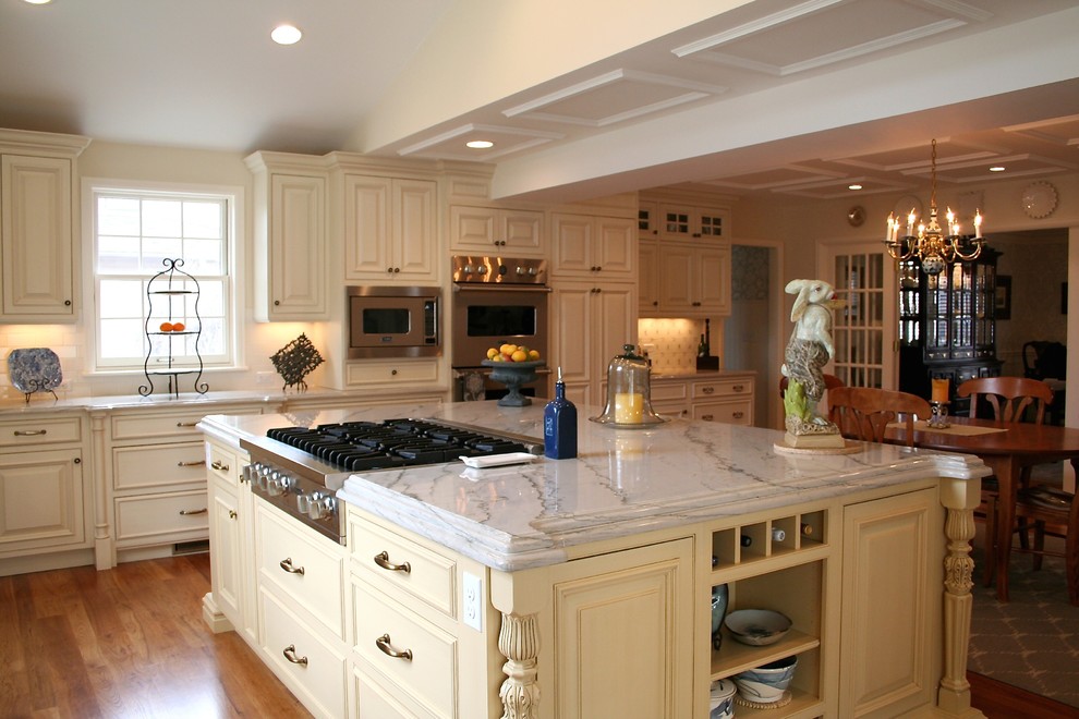 Foto di una cucina tradizionale con ante bianche, top in granito, paraspruzzi in gres porcellanato, elettrodomestici in acciaio inossidabile e parquet chiaro