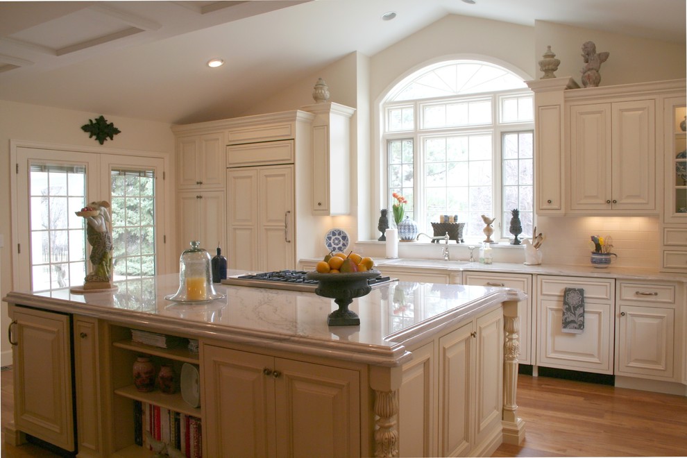 Photo of a traditional l-shaped kitchen/diner in Denver with white cabinets, granite worktops, porcelain splashback, stainless steel appliances, light hardwood flooring and an island.