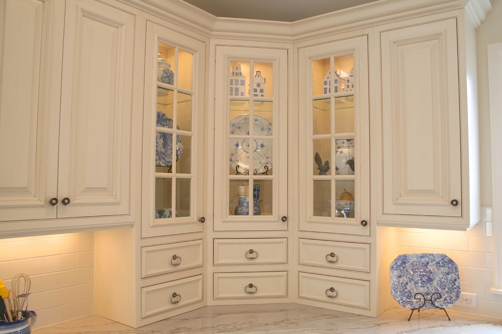 Foto de cocina clásica con puertas de armario blancas, encimera de granito, salpicadero de azulejos de porcelana, electrodomésticos de acero inoxidable, suelo de madera clara y una isla