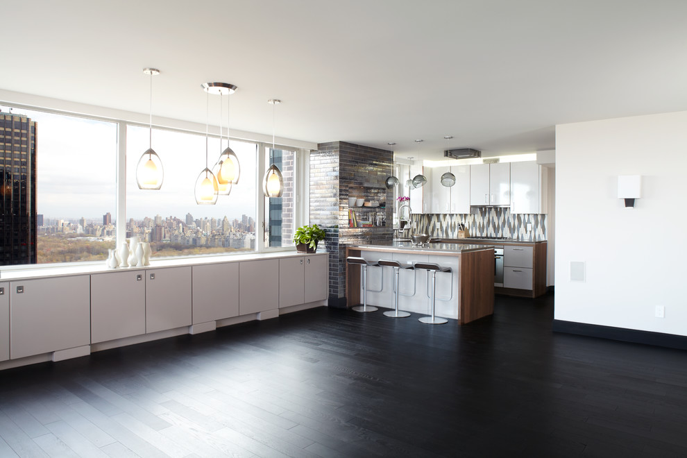 ニューヨークにある広いコンテンポラリースタイルのおしゃれなキッチン (フラットパネル扉のキャビネット、白いキャビネット、人工大理石カウンター、メタリックのキッチンパネル、濃色無垢フローリング、黒い床) の写真