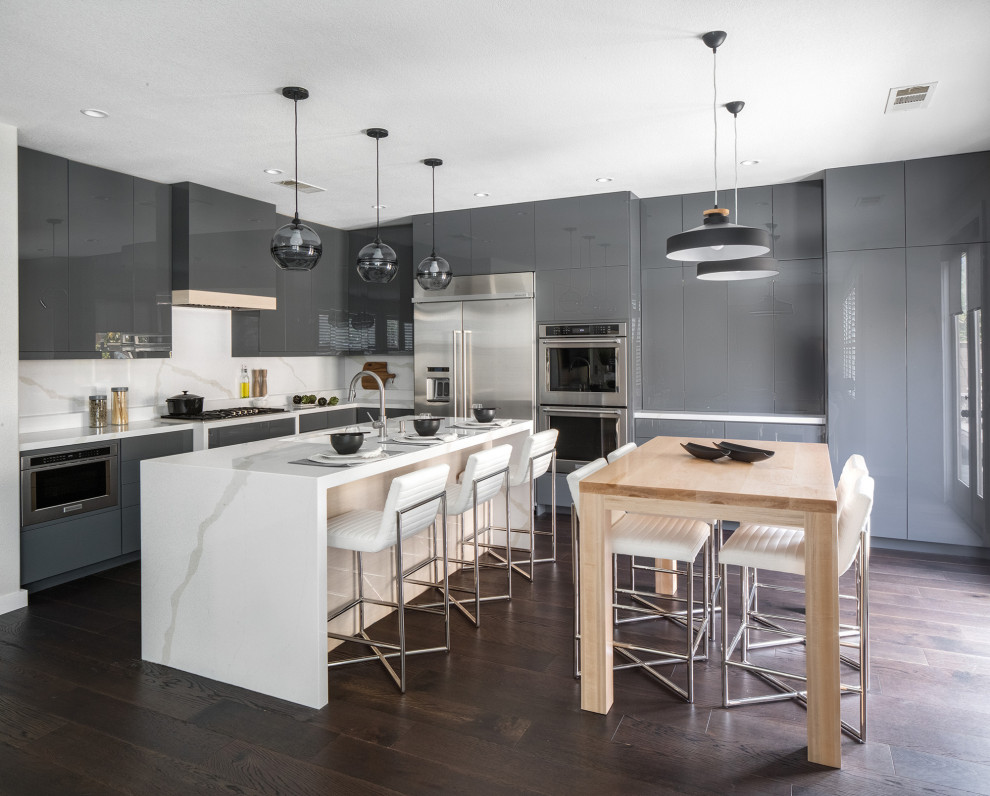 This is an example of a large contemporary l-shaped kitchen in Other with engineered stone countertops, white splashback, stone slab splashback, an island, white worktops, an integrated sink, flat-panel cabinets, grey cabinets, stainless steel appliances, dark hardwood flooring and brown floors.