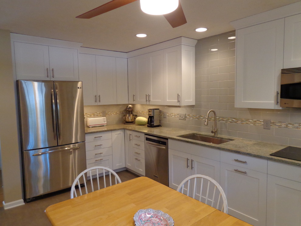Example of a mid-sized transitional l-shaped linoleum floor eat-in kitchen design in Raleigh with an undermount sink, recessed-panel cabinets, white cabinets, granite countertops, gray backsplash, subway tile backsplash, stainless steel appliances and no island