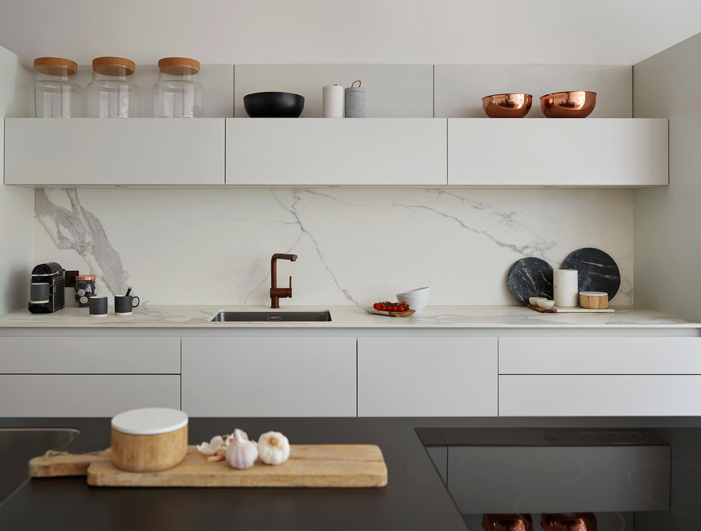 Große Moderne Küche mit Unterbauwaschbecken, flächenbündigen Schrankfronten, weißen Schränken, Küchenrückwand in Weiß, Rückwand aus Stein und Kücheninsel in Sonstige