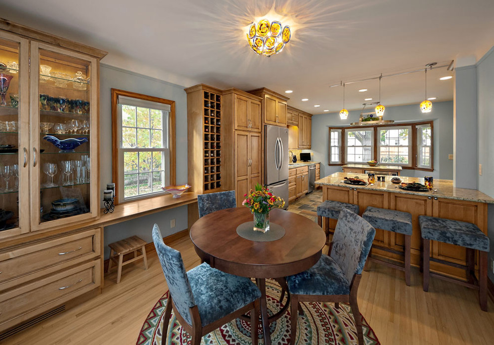 Mittelgroße Stilmix Küche mit Schrankfronten mit vertiefter Füllung, hellen Holzschränken, Quarzwerkstein-Arbeitsplatte, Küchengeräten aus Edelstahl und hellem Holzboden in Minneapolis