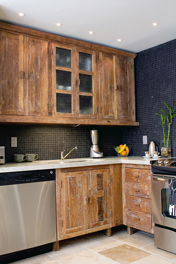 Small rustic l-shaped kitchen/diner in Toronto with a double-bowl sink, flat-panel cabinets, light wood cabinets, granite worktops, black splashback, ceramic splashback, stainless steel appliances, travertine flooring and no island.