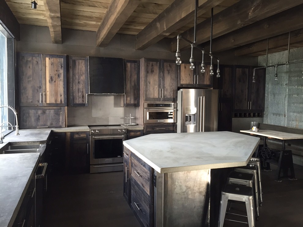Large urban l-shaped dark wood floor open concept kitchen photo in Other with a farmhouse sink, recessed-panel cabinets, distressed cabinets, concrete countertops, metallic backsplash, metal backsplash, stainless steel appliances and an island