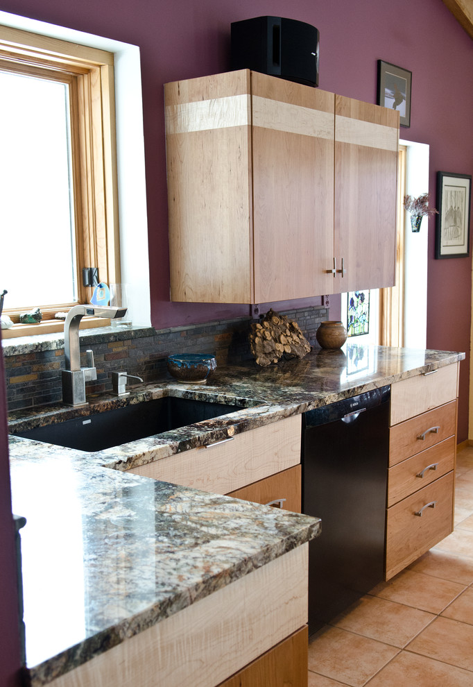 Cette image montre une cuisine traditionnelle en bois clair avec un plan de travail en granite, une crédence multicolore, un électroménager noir et îlot.