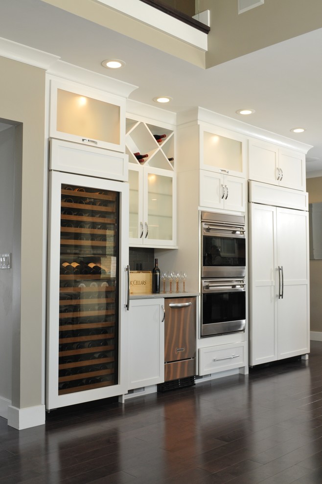 Eat-in kitchen - large traditional l-shaped medium tone wood floor eat-in kitchen idea in Chicago with an undermount sink, shaker cabinets, white cabinets, marble countertops, gray backsplash, subway tile backsplash, paneled appliances and an island