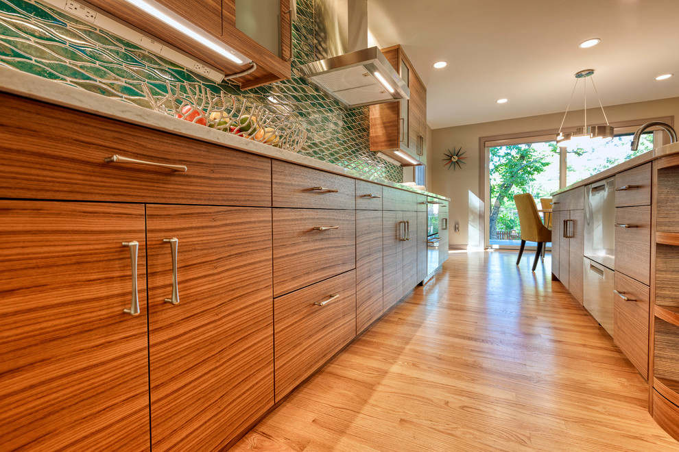 Cette image montre une cuisine américaine parallèle traditionnelle en bois brun avec un placard à porte plane, un plan de travail en quartz modifié, une crédence verte, îlot et un plan de travail beige.