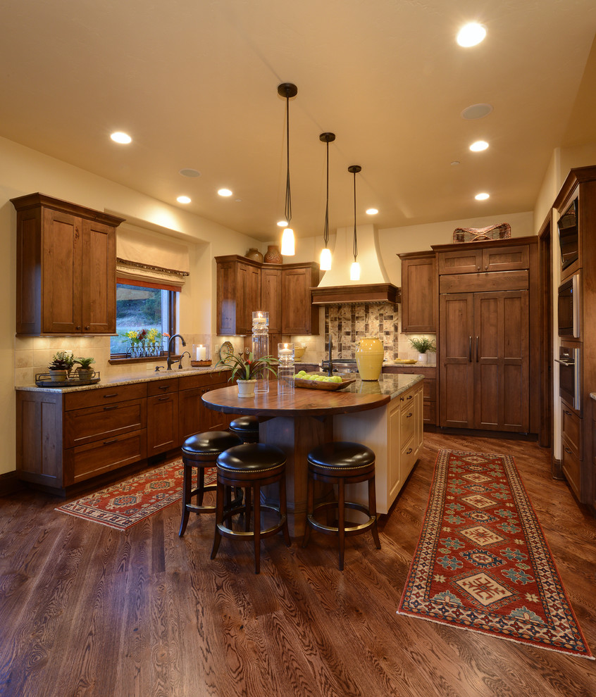 Klassische Küche in U-Form mit Schrankfronten im Shaker-Stil, hellbraunen Holzschränken, Küchenrückwand in Beige und braunem Holzboden in Denver