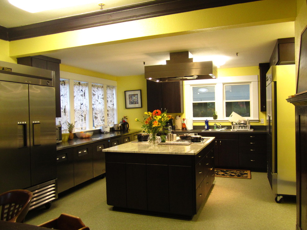 ポートランドにあるコンテンポラリースタイルのおしゃれなキッチン (ドロップインシンク、フラットパネル扉のキャビネット、黒いキャビネット、ステンレスカウンター、黒いキッチンパネル、シルバーの調理設備) の写真