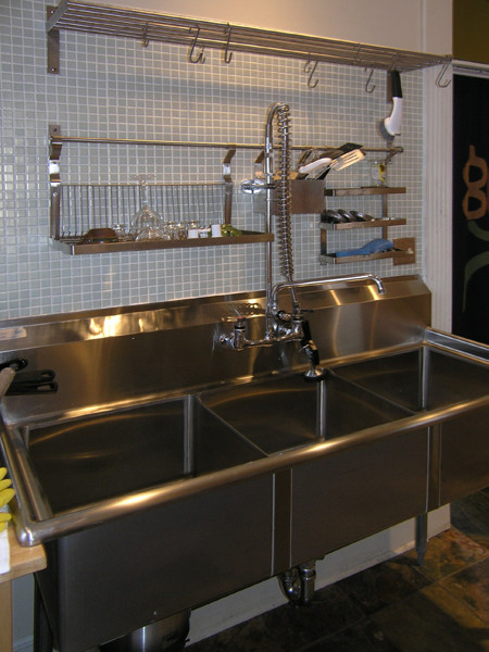 Foto di una grande cucina contemporanea con lavello a tripla vasca, ante in legno chiaro, top in legno, paraspruzzi verde, paraspruzzi con piastrelle di vetro e elettrodomestici in acciaio inossidabile