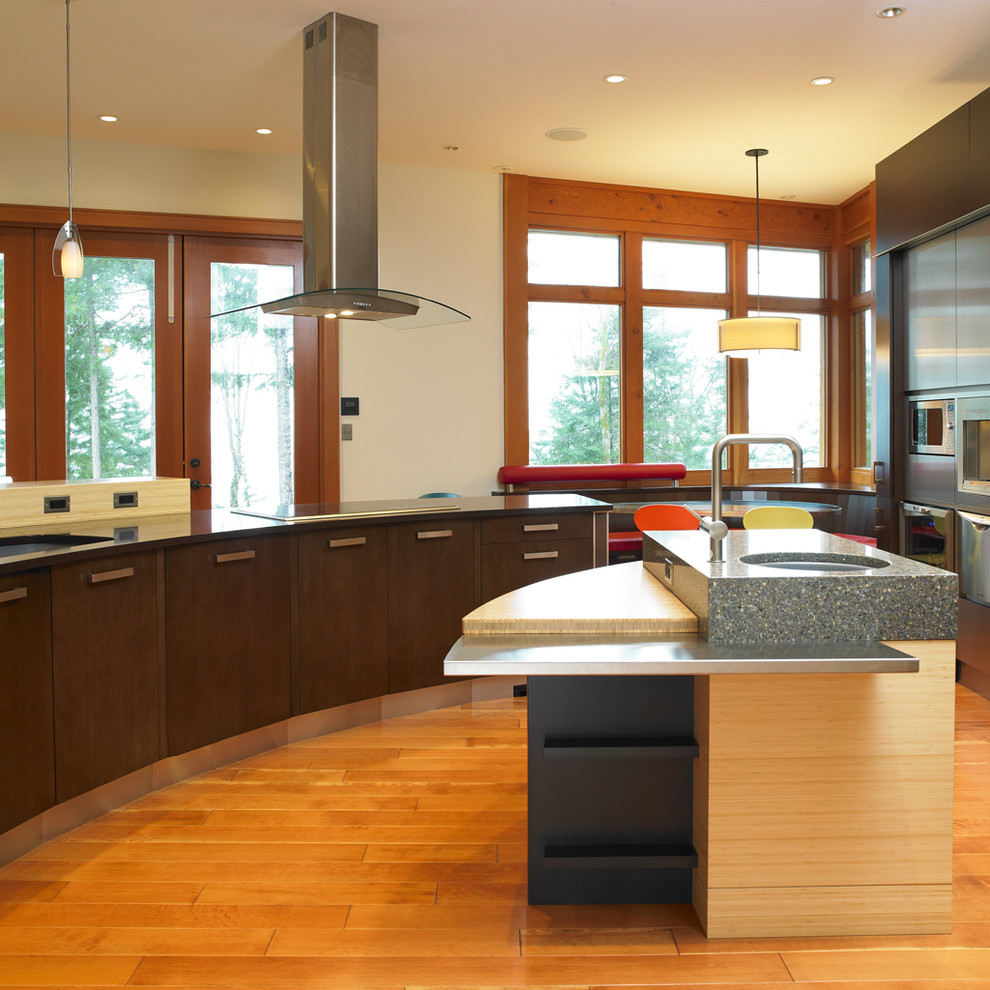 Пример оригинального дизайна: кухня в стиле модернизм с врезной мойкой, плоскими фасадами и темными деревянными фасадами