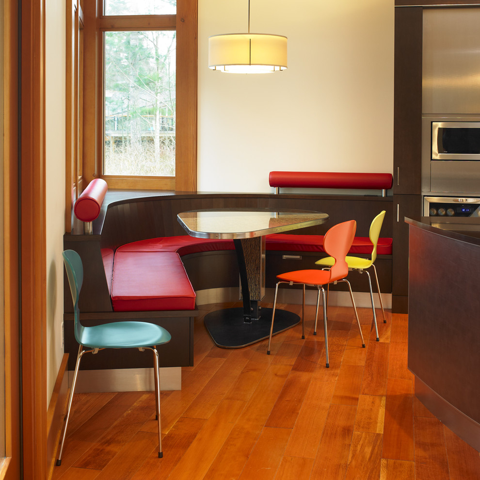 Diseño de cocina comedor minimalista con armarios con paneles lisos, puertas de armario de madera en tonos medios y electrodomésticos de acero inoxidable