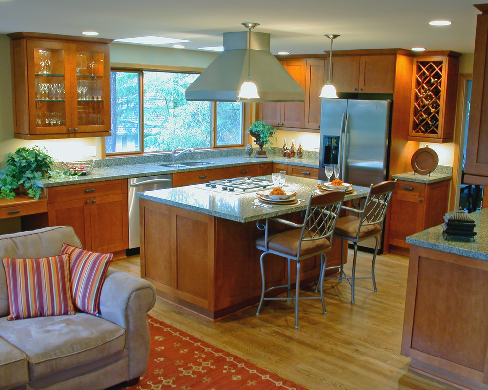 Example of a mid-sized arts and crafts u-shaped light wood floor open concept kitchen design in Seattle with an undermount sink, recessed-panel cabinets, medium tone wood cabinets, granite countertops, gray backsplash, stone slab backsplash, stainless steel appliances and an island
