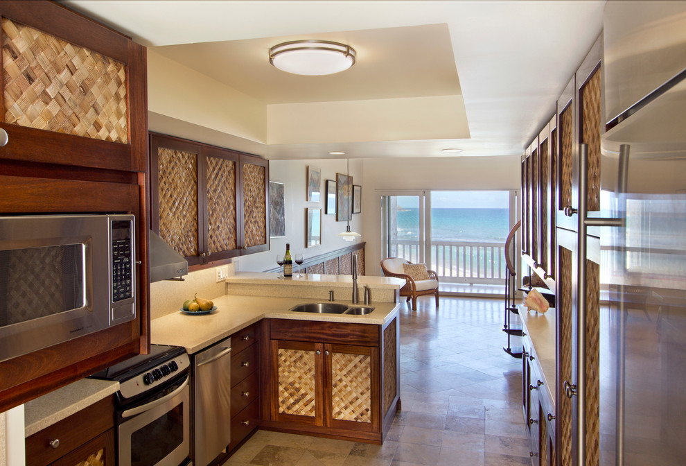 Immagine di una cucina a L tropicale con lavello sottopiano, elettrodomestici in acciaio inossidabile e pavimento con piastrelle in ceramica