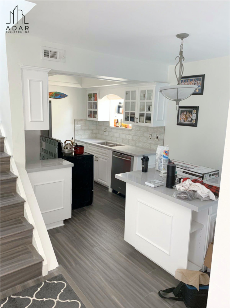 Idéer för ett litet modernt grå kök, med luckor med upphöjd panel, vita skåp, marmorbänkskiva, vitt stänkskydd, rostfria vitvaror, mellanmörkt trägolv, en köksö och brunt golv