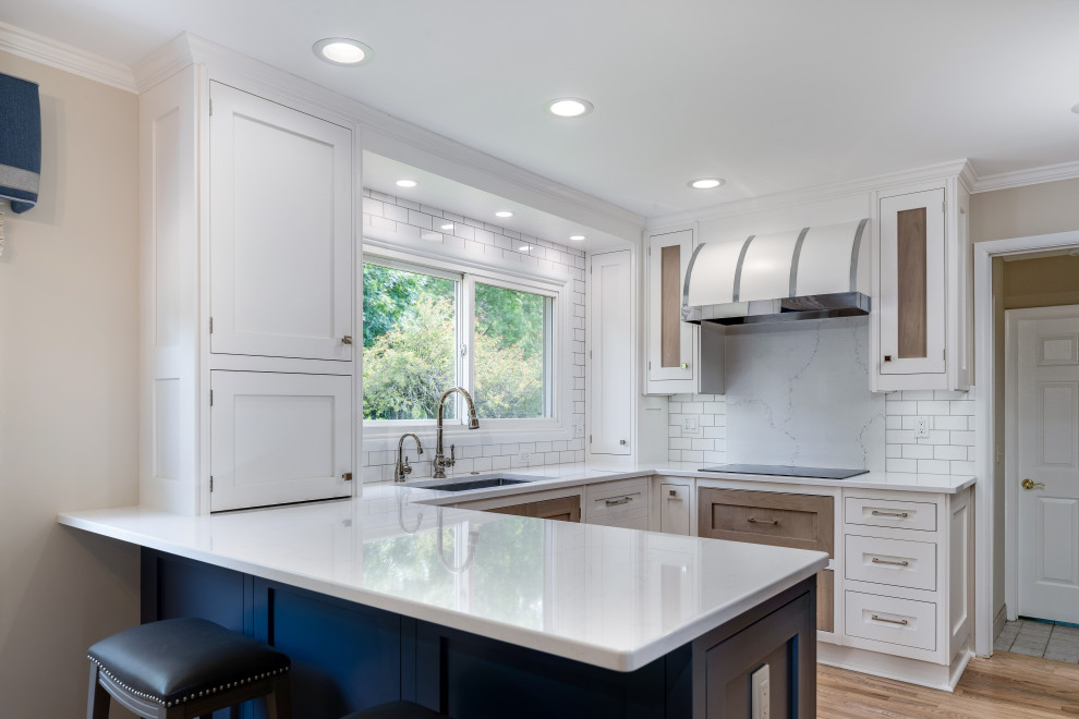 Inspiration for a small transitional u-shaped medium tone wood floor and brown floor eat-in kitchen remodel in Detroit with an undermount sink, recessed-panel cabinets, white cabinets, quartz countertops, white backsplash, quartz backsplash, stainless steel appliances, a peninsula and white countertops