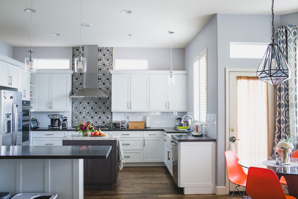 Inspiration for a large transitional u-shaped medium tone wood floor eat-in kitchen remodel in San Francisco with a farmhouse sink, shaker cabinets, white cabinets, quartz countertops, black backsplash, subway tile backsplash, stainless steel appliances and an island