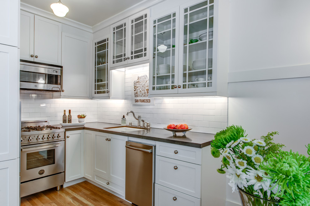 Photo of a small contemporary galley kitchen pantry in San Francisco with a submerged sink, shaker cabinets, white cabinets, engineered stone countertops, brown splashback, ceramic splashback, stainless steel appliances, light hardwood flooring and no island.