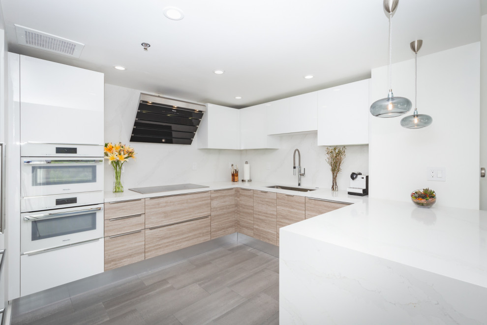 Inspiration for a small contemporary u-shaped medium tone wood floor and gray floor eat-in kitchen remodel in San Francisco with an undermount sink, flat-panel cabinets, white cabinets, quartz countertops, white backsplash, white appliances, a peninsula and white countertops