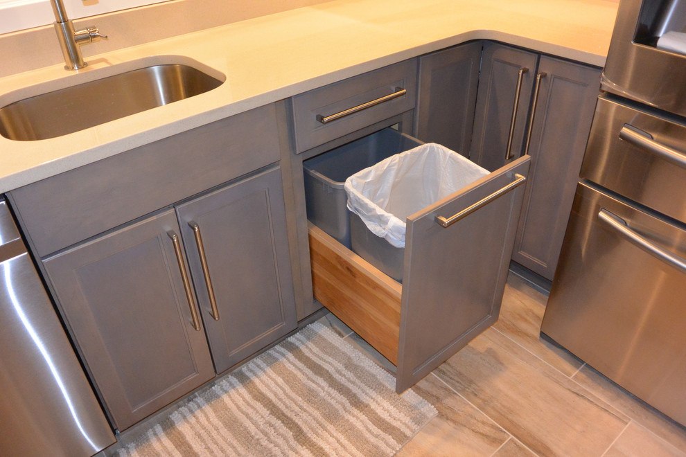 Example of a small transitional u-shaped porcelain tile and brown floor eat-in kitchen design in DC Metro with an undermount sink, shaker cabinets, gray cabinets, quartz countertops, gray backsplash, mosaic tile backsplash, stainless steel appliances, a peninsula and gray countertops