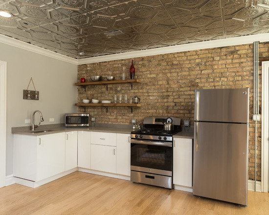 Example of a mid-sized eclectic galley medium tone wood floor enclosed kitchen design in Chicago with an undermount sink, louvered cabinets, white cabinets, granite countertops, multicolored backsplash, brick backsplash, stainless steel appliances and no island