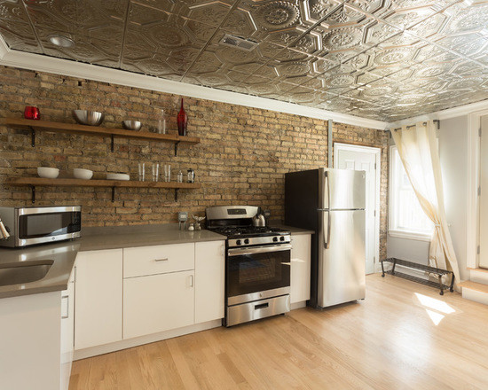 Enclosed kitchen - mid-sized eclectic galley medium tone wood floor enclosed kitchen idea in Chicago with an undermount sink, louvered cabinets, white cabinets, granite countertops, multicolored backsplash, brick backsplash, stainless steel appliances and no island
