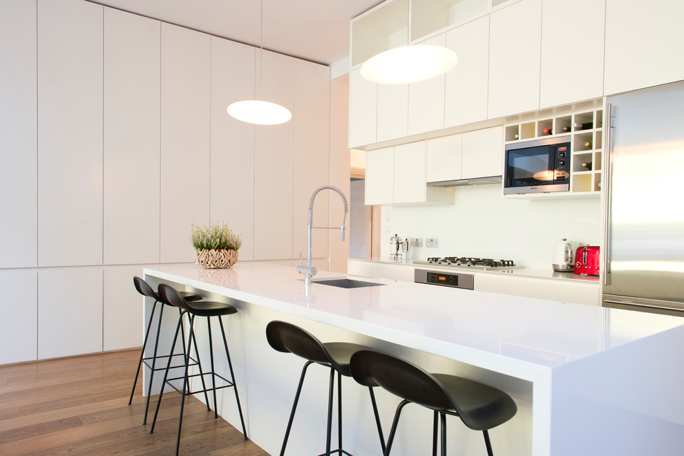 Offene, Große Moderne Küche mit Einbauwaschbecken, weißen Schränken, Küchenrückwand in Weiß und Kücheninsel in London