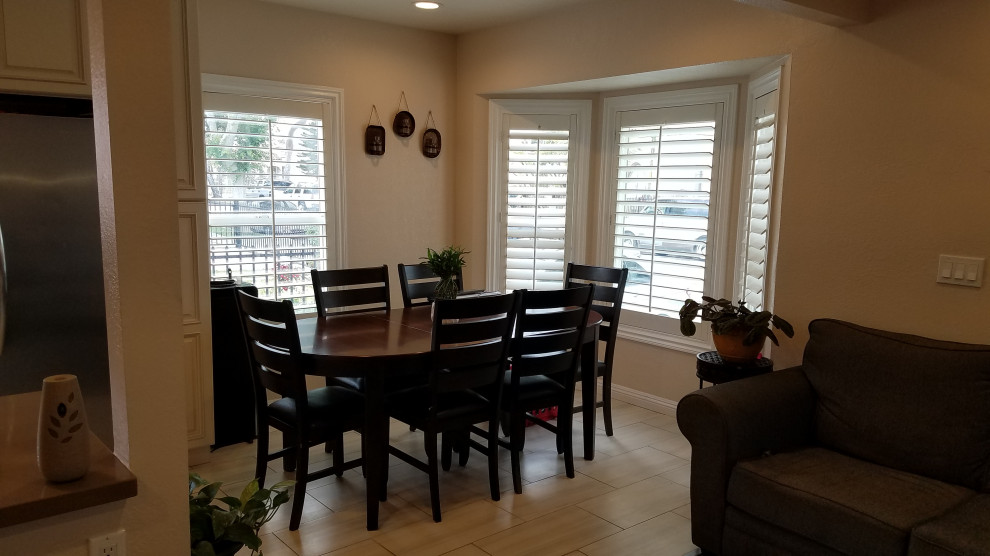 Immagine di una sala da pranzo aperta verso la cucina minimal di medie dimensioni con pavimento in terracotta e pavimento beige