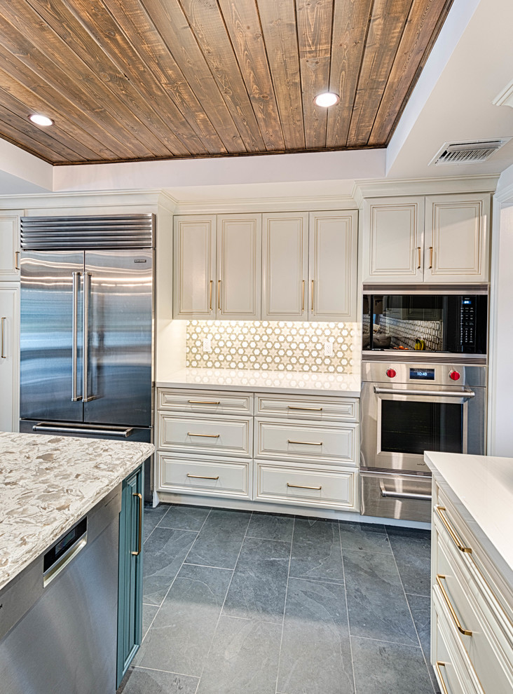 Exempel på ett stort klassiskt vit vitt kök, med en undermonterad diskho, luckor med profilerade fronter, vita skåp, bänkskiva i kvartsit, flerfärgad stänkskydd, stänkskydd i cementkakel, rostfria vitvaror, skiffergolv, en köksö och grått golv