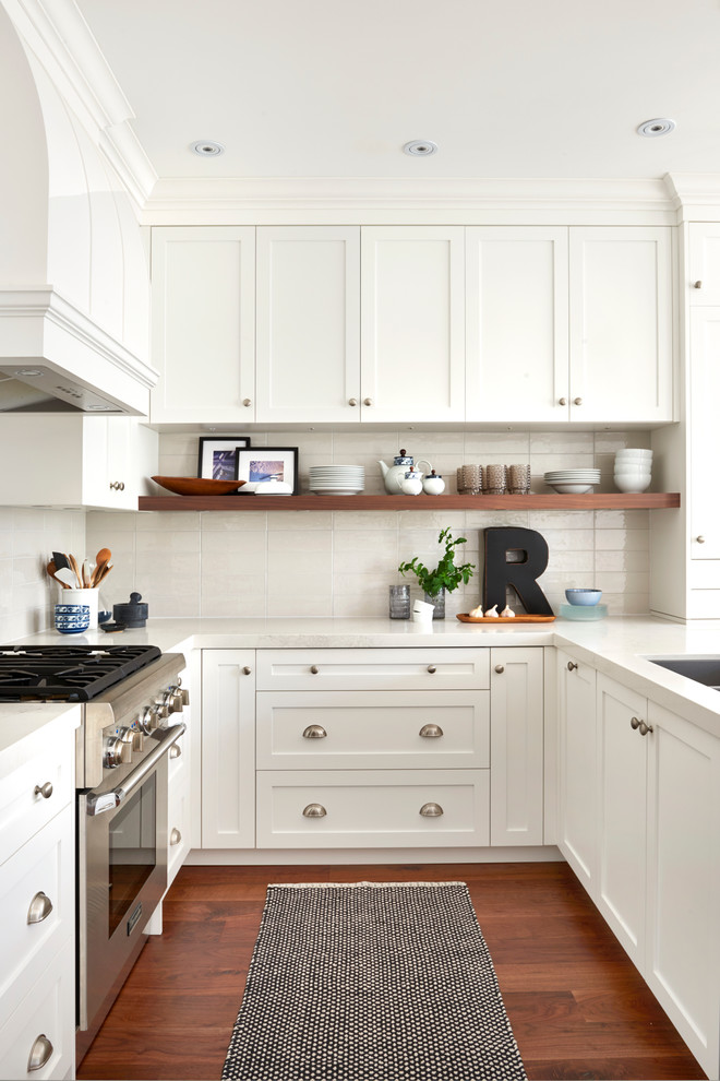 Klassische Küche in U-Form mit Unterbauwaschbecken, Schrankfronten im Shaker-Stil, weißen Schränken, Küchenrückwand in Beige, Küchengeräten aus Edelstahl, dunklem Holzboden und Halbinsel in Toronto