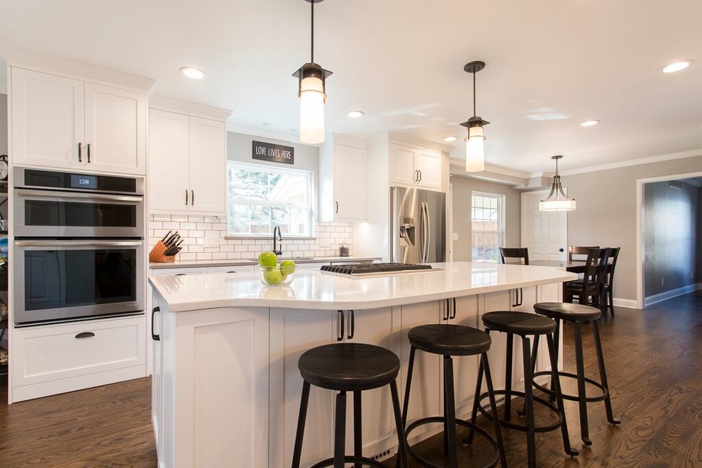 Eat-in kitchen - large transitional single-wall dark wood floor eat-in kitchen idea in Denver with an undermount sink, shaker cabinets, white cabinets, quartz countertops, white backsplash, subway tile backsplash, stainless steel appliances and an island