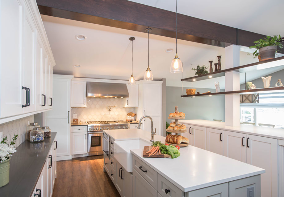 Inspiration for a large transitional galley medium tone wood floor and brown floor open concept kitchen remodel in Detroit with a farmhouse sink, shaker cabinets, white cabinets, quartz countertops, white backsplash, stainless steel appliances, two islands, white countertops and glass tile backsplash