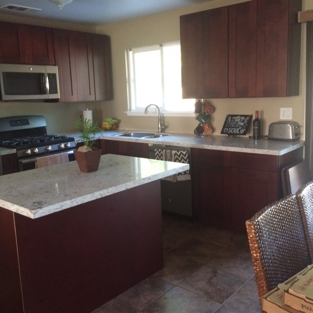 Exempel på ett litet modernt kök, med en undermonterad diskho, skåp i shakerstil, skåp i mörkt trä, granitbänkskiva, rostfria vitvaror, klinkergolv i porslin och en köksö