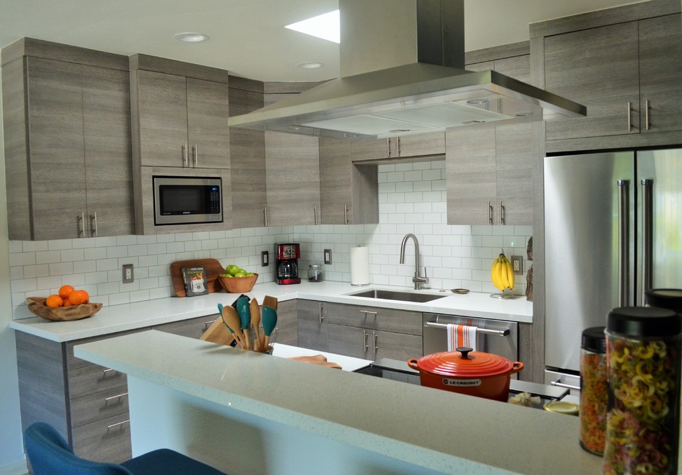 Small modern l-shaped open plan kitchen in San Diego with a submerged sink, flat-panel cabinets, grey cabinets, quartz worktops, white splashback, metro tiled splashback, stainless steel appliances and an island.