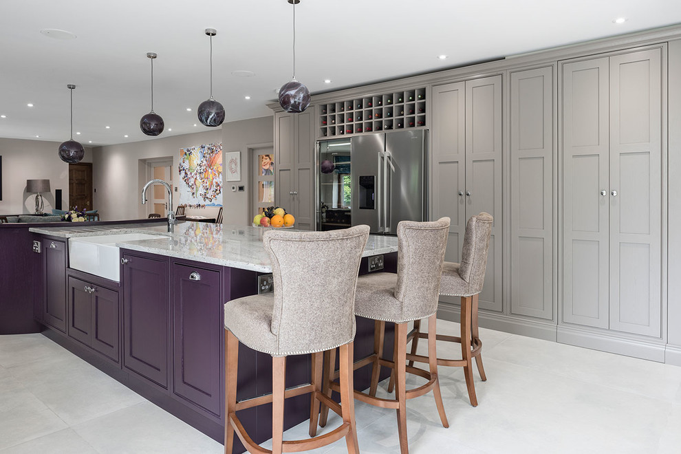 Example of a huge trendy u-shaped ceramic tile and gray floor open concept kitchen design in Surrey with a farmhouse sink, shaker cabinets, purple cabinets, granite countertops, beige backsplash, glass sheet backsplash, stainless steel appliances, an island and multicolored countertops