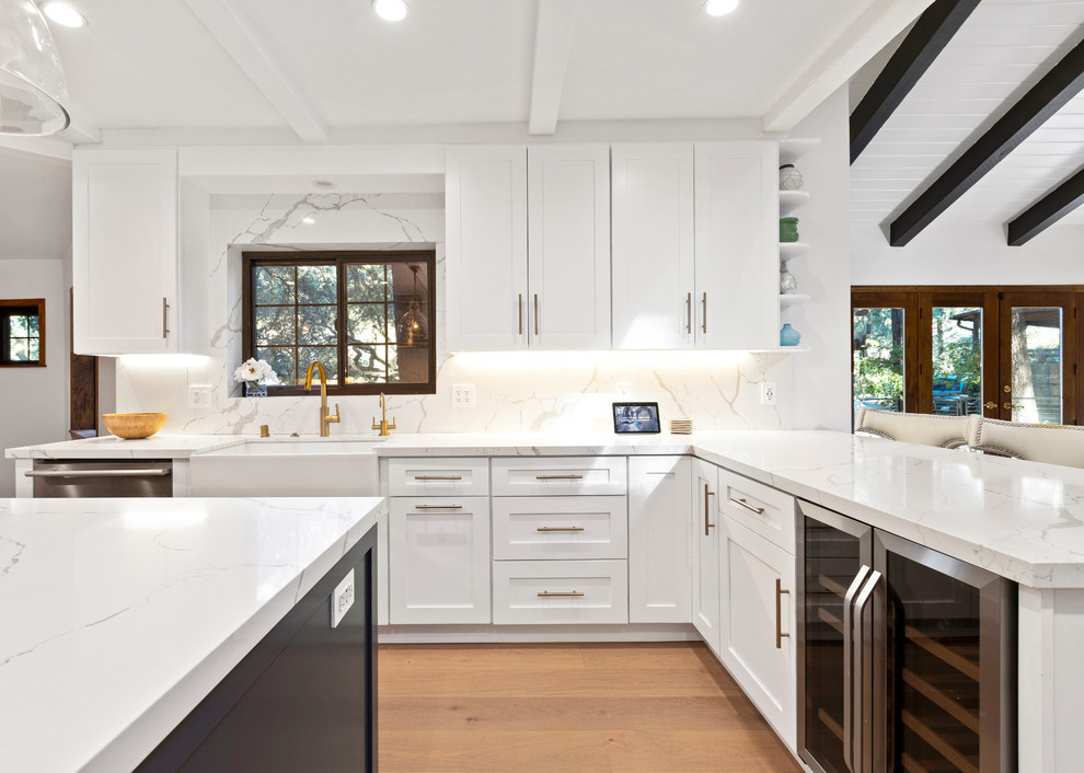 Design ideas for a large traditional open plan kitchen in Los Angeles with shaker cabinets, engineered stone countertops, multi-coloured splashback, porcelain splashback, stainless steel appliances, light hardwood flooring, an island, beige floors and white worktops.