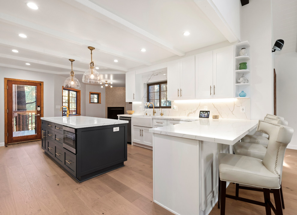 Design ideas for a large classic open plan kitchen in Los Angeles with shaker cabinets, engineered stone countertops, multi-coloured splashback, porcelain splashback, stainless steel appliances, light hardwood flooring, an island, beige floors and white worktops.