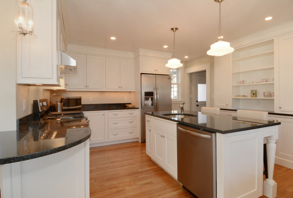 Photo of a large classic l-shaped kitchen in Boston with a submerged sink, shaker cabinets, white cabinets, marble worktops, stainless steel appliances, medium hardwood flooring and an island.
