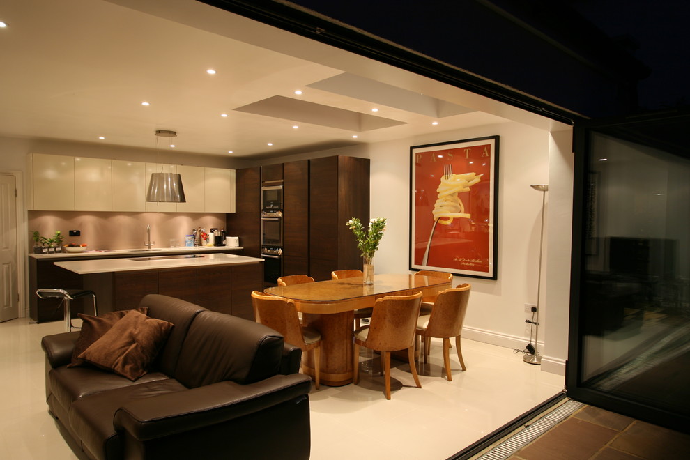 Foto di una cucina minimalista di medie dimensioni con lavello sottopiano, ante lisce, ante in legno bruno, top in granito, elettrodomestici in acciaio inossidabile e pavimento in gres porcellanato