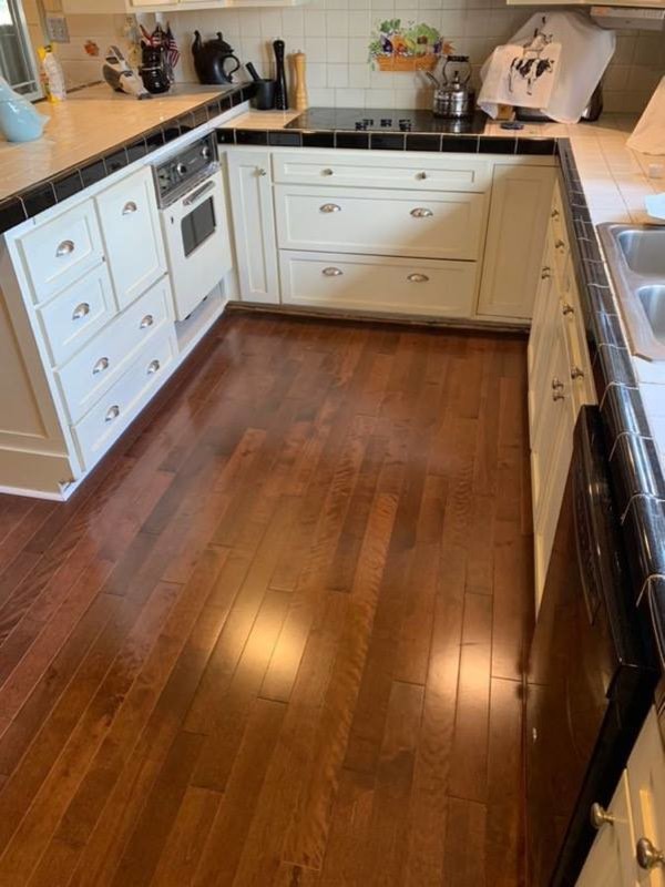 Inspiration for a mid-sized timeless u-shaped medium tone wood floor and brown floor enclosed kitchen remodel in Seattle with a double-bowl sink, shaker cabinets, white cabinets, tile countertops, white backsplash, ceramic backsplash, stainless steel appliances, a peninsula and beige countertops